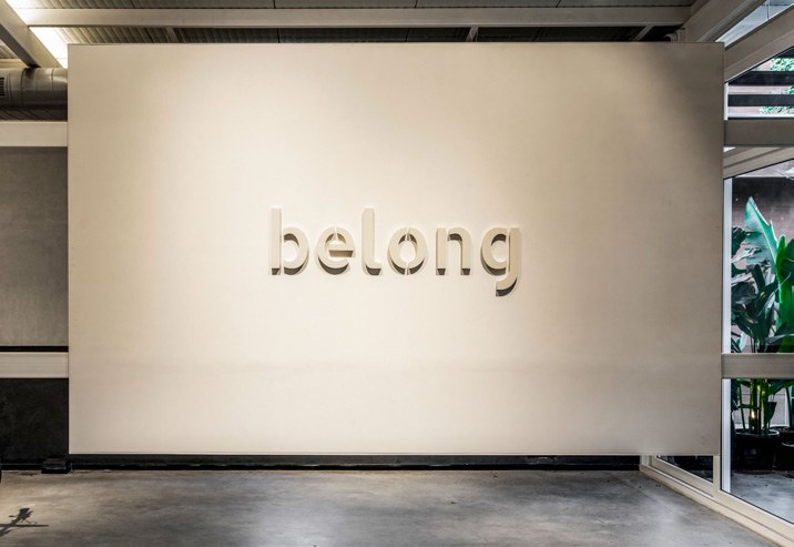 The belong sign on the studio wall, with plants.
